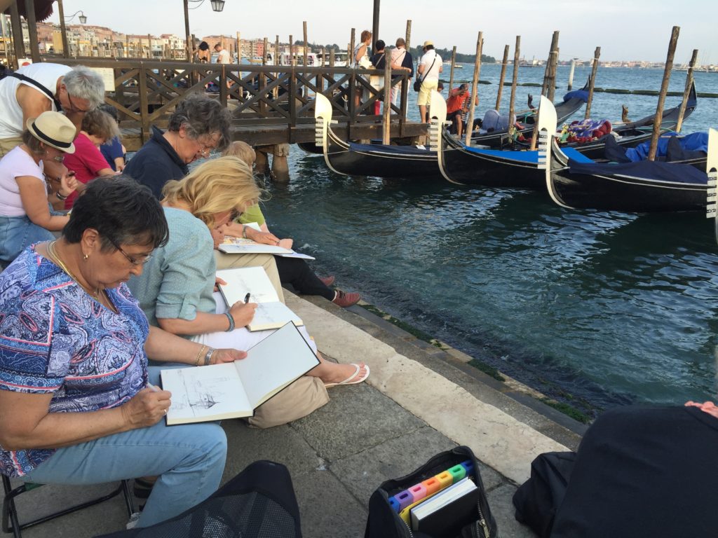 Artists in Venice, Italy create by the waterfront.